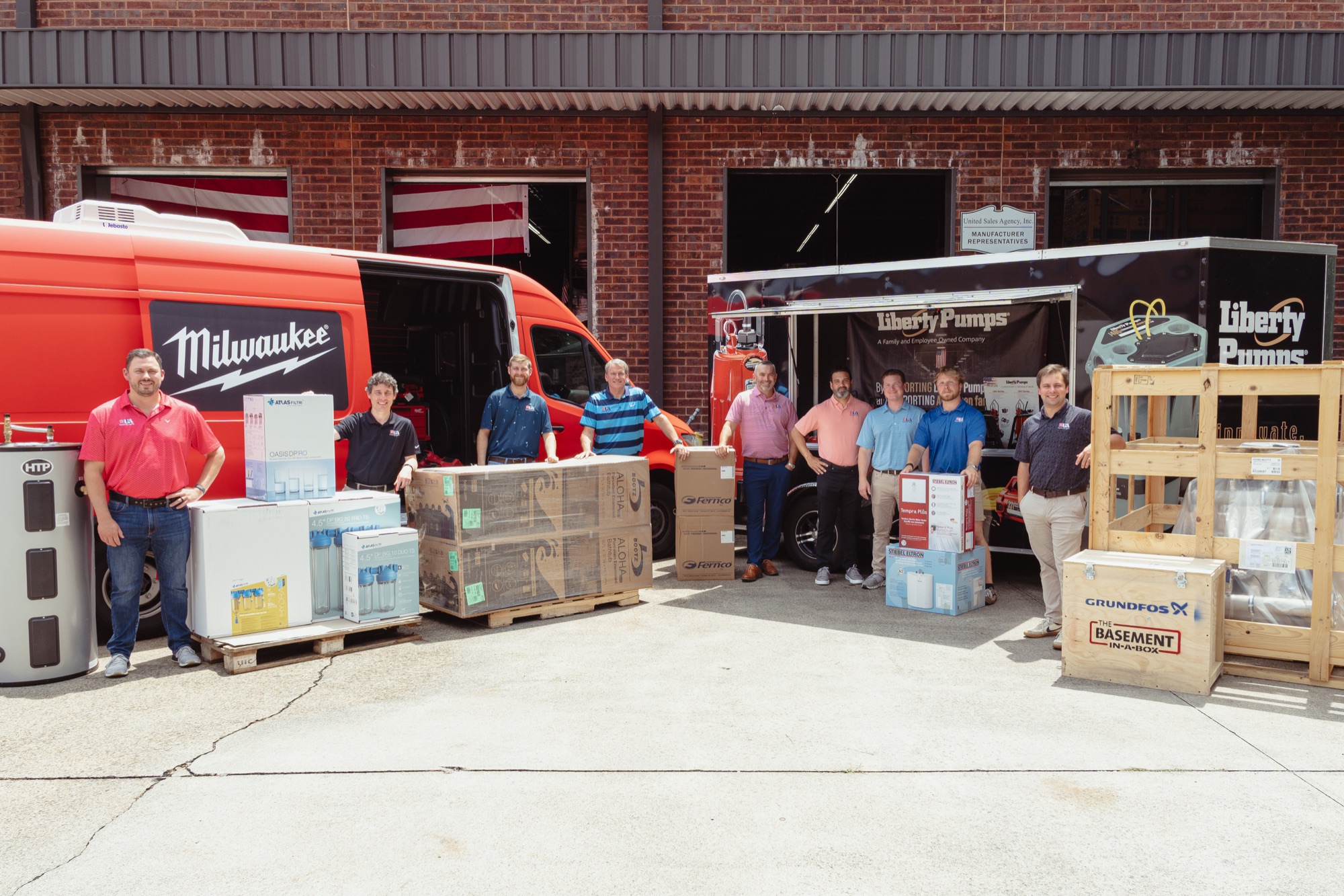 United Sales Agency team outside the Acworth warehouse with manufacturer products and service vehicles